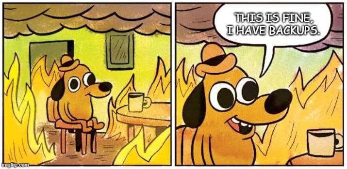 'this is fine' dog in a room on fire meme, with the speech bubble saying 'this is fine, I have backups.'